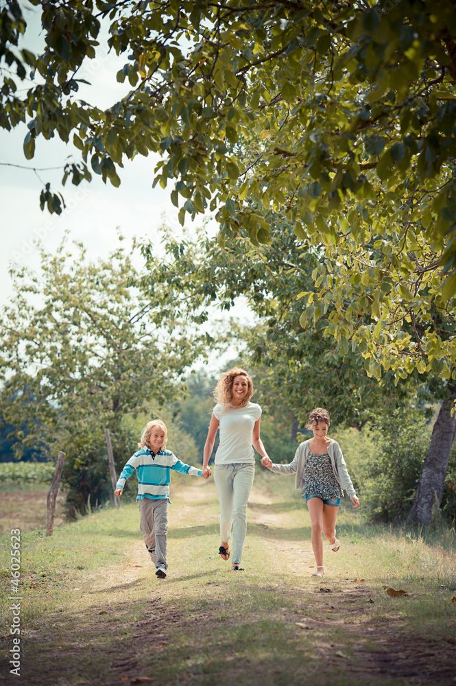 Fototapeta premium Beautiful Young Woman with Two Children Outside