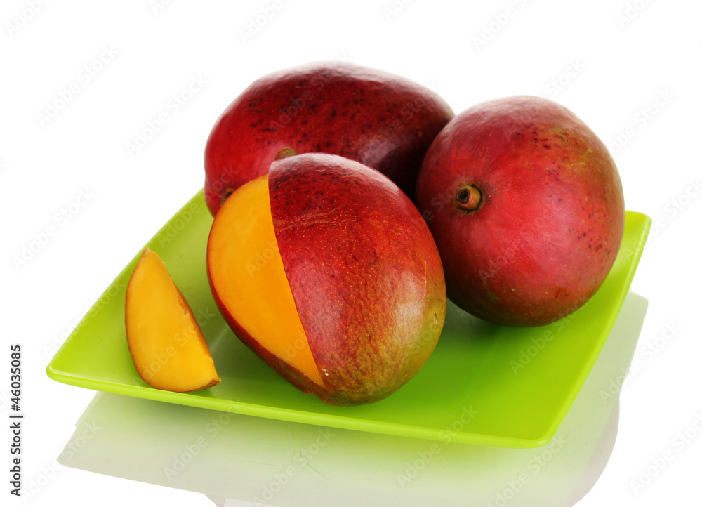 Ripe appetizing mango on green plate isolated on white Ripe appetizing mango on green plate isolated on white