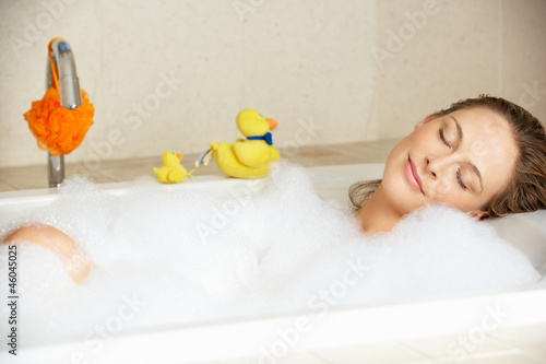 Fotografie Woman Relaxing In Bubble Filled Bath