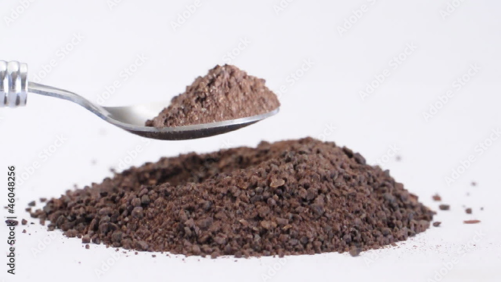 Raw cocoa powder on a spoon Raw cocoa powder on a spoon