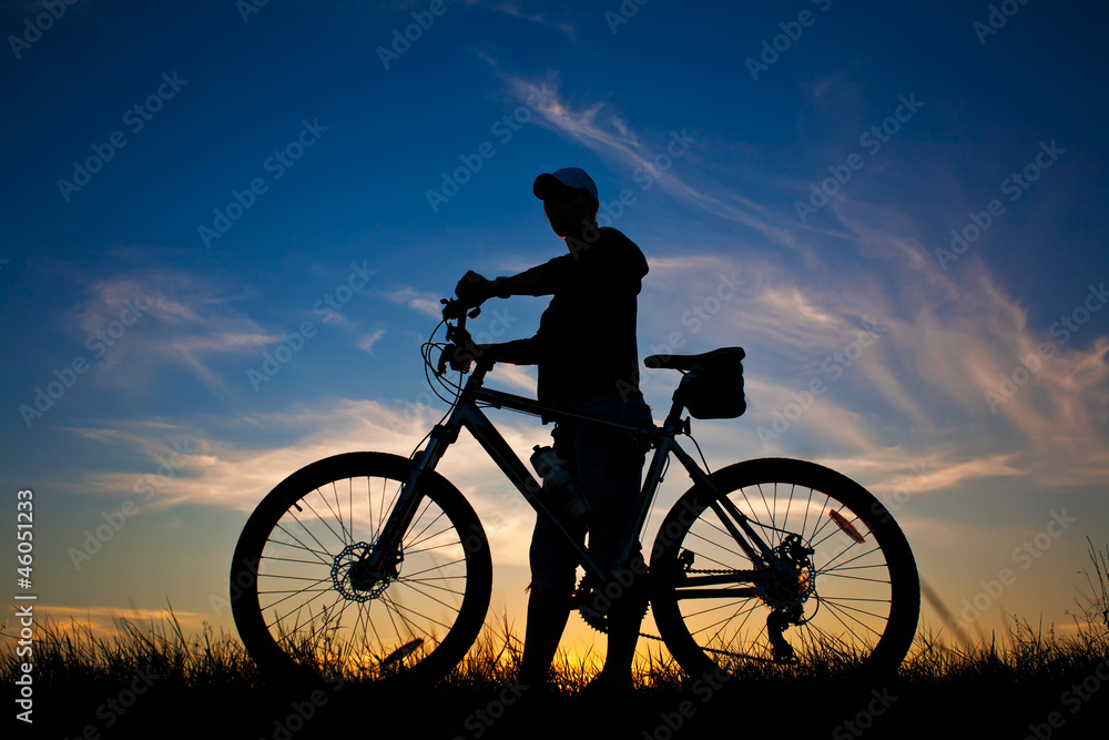 Fototapeta premium cyclist with a bike silhouette on a blue sky