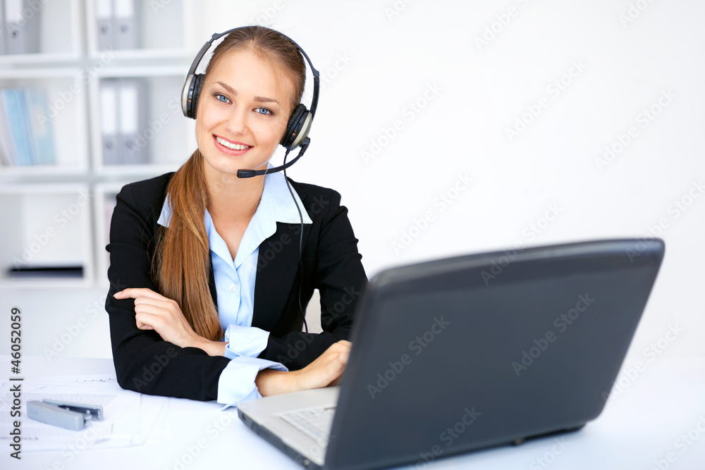 Portrait of pretty young female operator sitting at office desk Portrait of pretty young female operator sitting at office desk