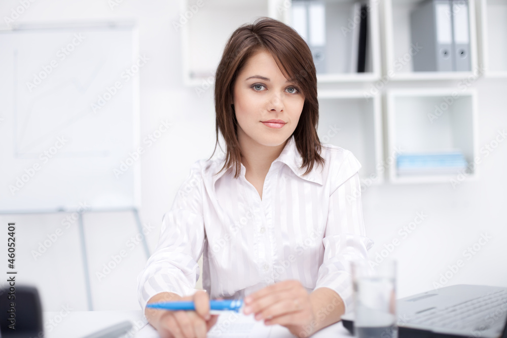 Portrait of beautiful young business woman sitting at desk Portrait of beautiful young business woman sitting at desk