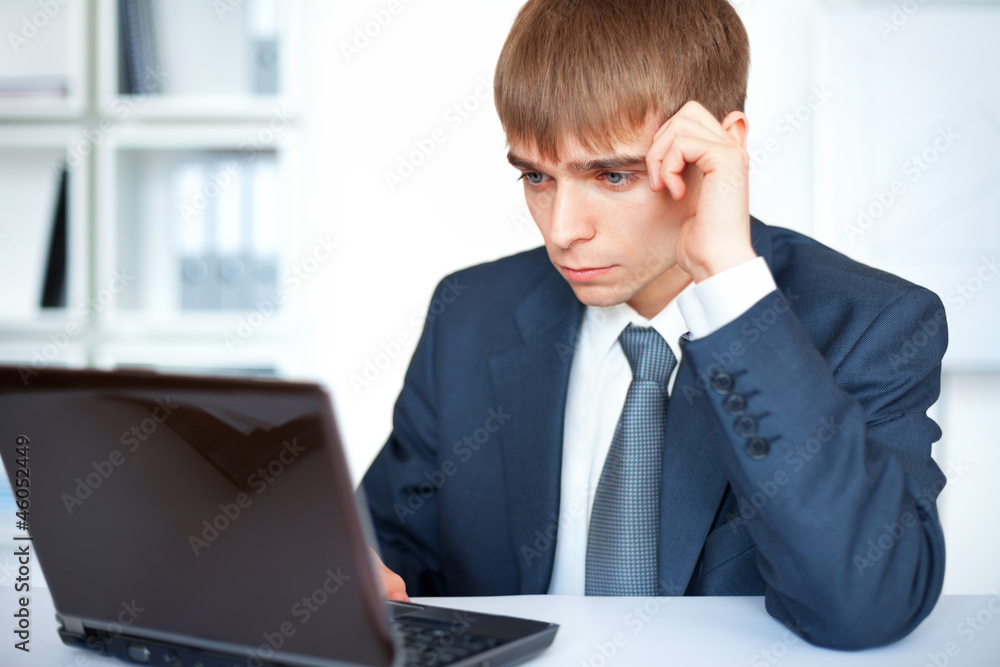 young businessman working on laptop in office young businessman working on laptop in office