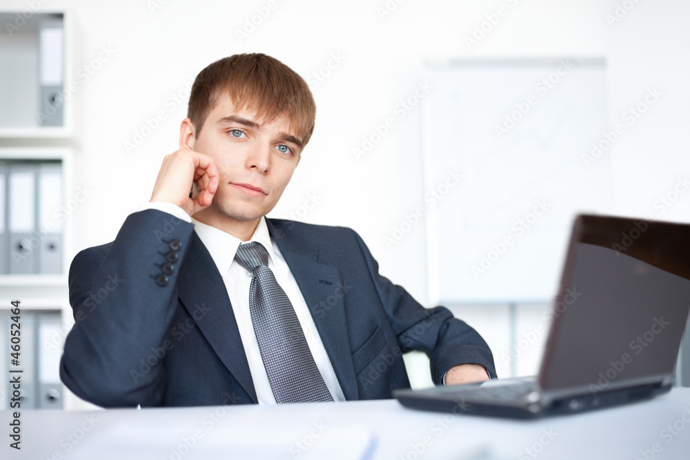 young businessman working on laptop in office young businessman working on laptop in office