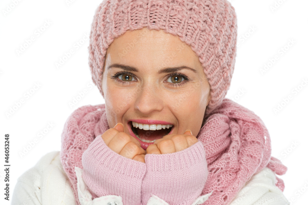 Happy woman in knit scarf, hat and mittens breathing on hands Happy woman in knit scarf, hat and mittens breathing on hands