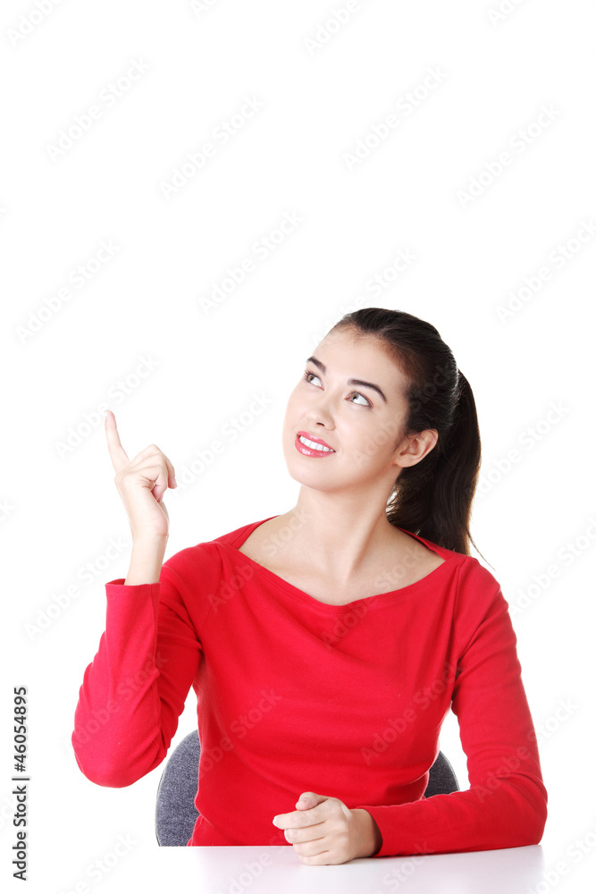 Woman sitting at the desk and pointing something Woman sitting at the desk and pointing something