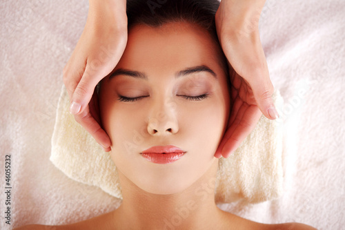 Woman enjoy receiving face massage at spa saloon