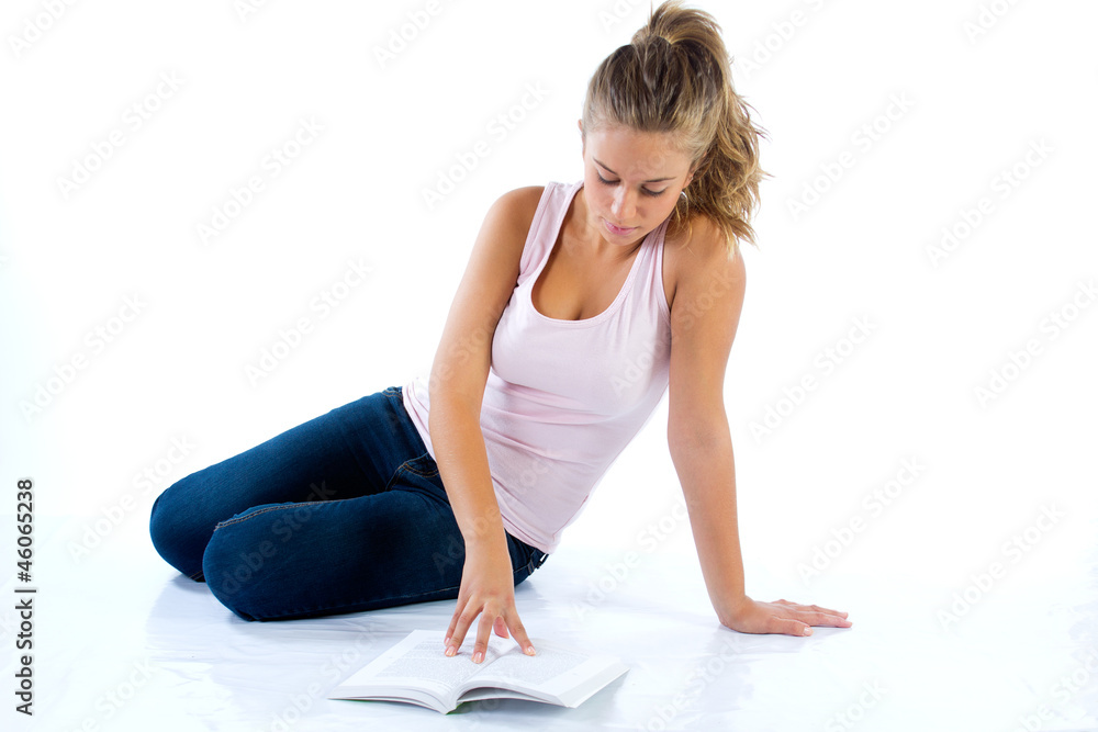 blonde student girl reading a book on the floor