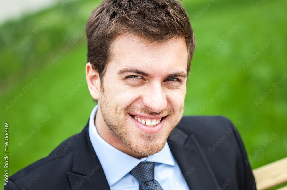 Smiling businessman sitting on a bench Smiling businessman sitting on a bench