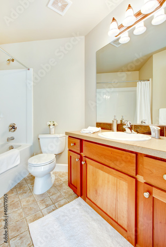 Bathroom with white tub  toilet and sink and wood cabinets.