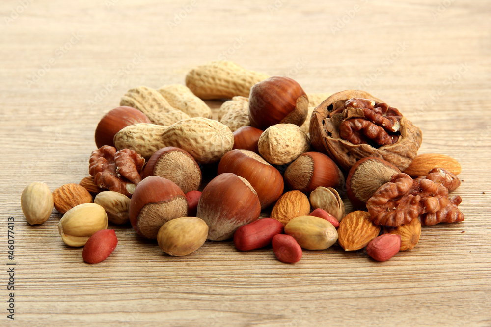 assortment of tasty nuts on wooden background