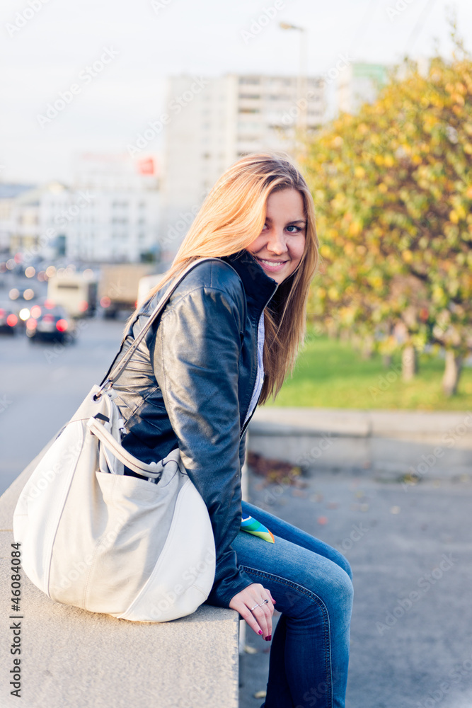 Fototapeta premium Young woman sitting at the railing.