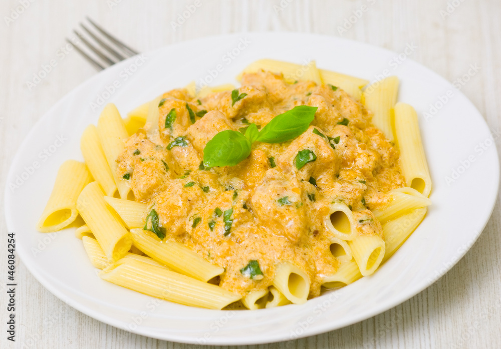 Penne pasta with chicken meat, cream sauce and basil Penne pasta with chicken meat, cream sauce and basil