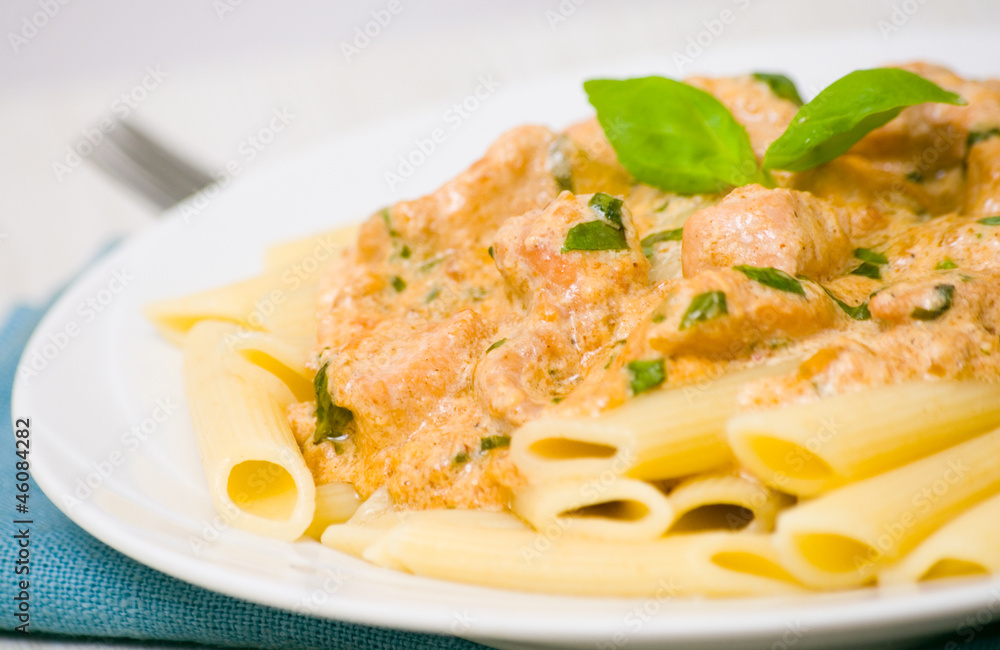 Penne pasta with chicken meat, cream sauce and basil Penne pasta with chicken meat, cream sauce and basil