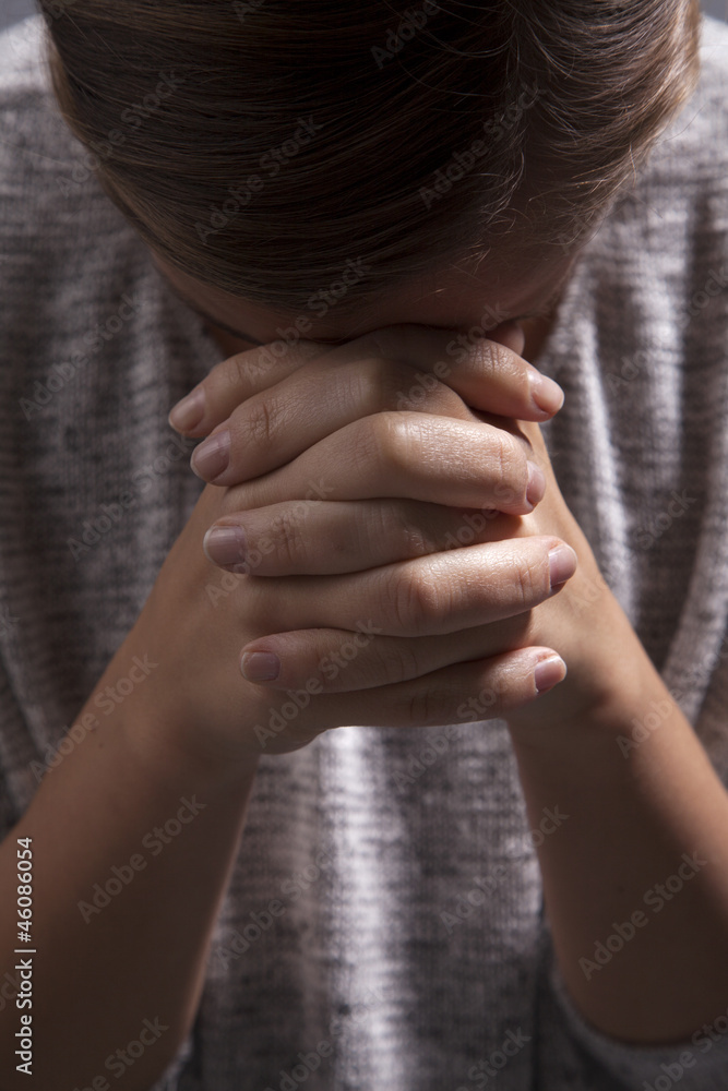 Woman Folds Hands and Prays