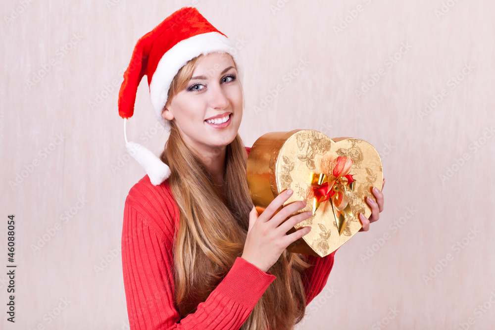 smiling woman wearing Santa Claus hat holding gift smiling woman wearing Santa Claus hat holding gift