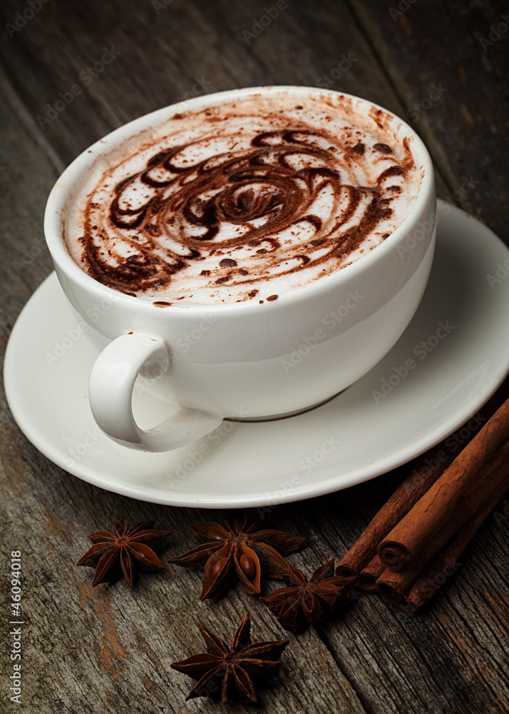 coffee cup and beans, cinnamon sticks, nuts and chocolate on woo coffee cup and beans, cinnamon sticks, nuts and chocolate on woo