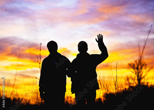 Photos Two men stand in the background of a sunset