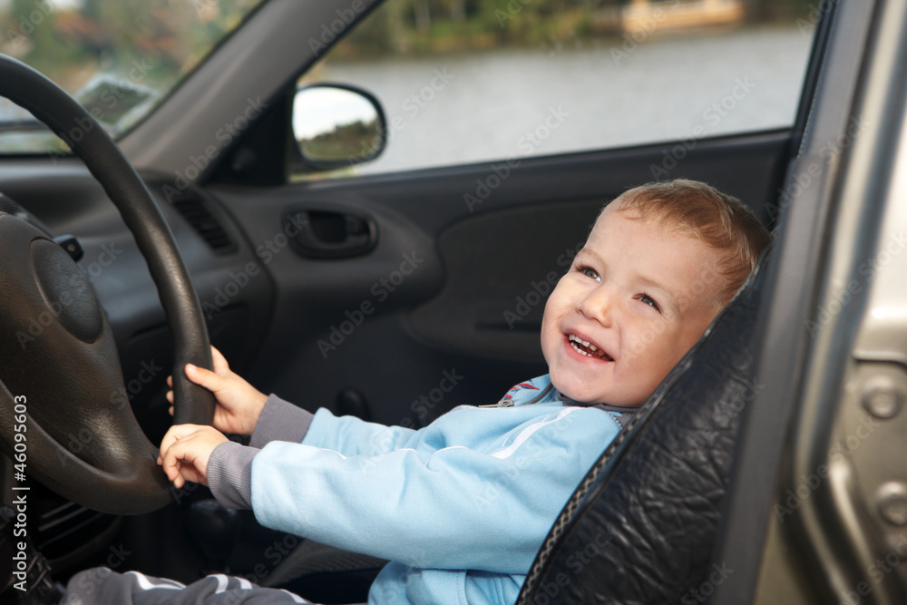 The boy sits in the automobile The boy sits in the automobile
