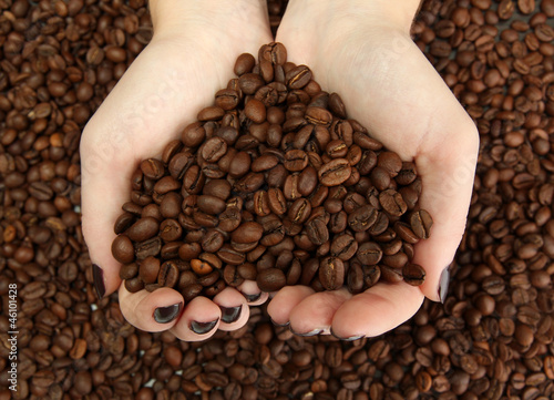 female hands with coffee beans, close up