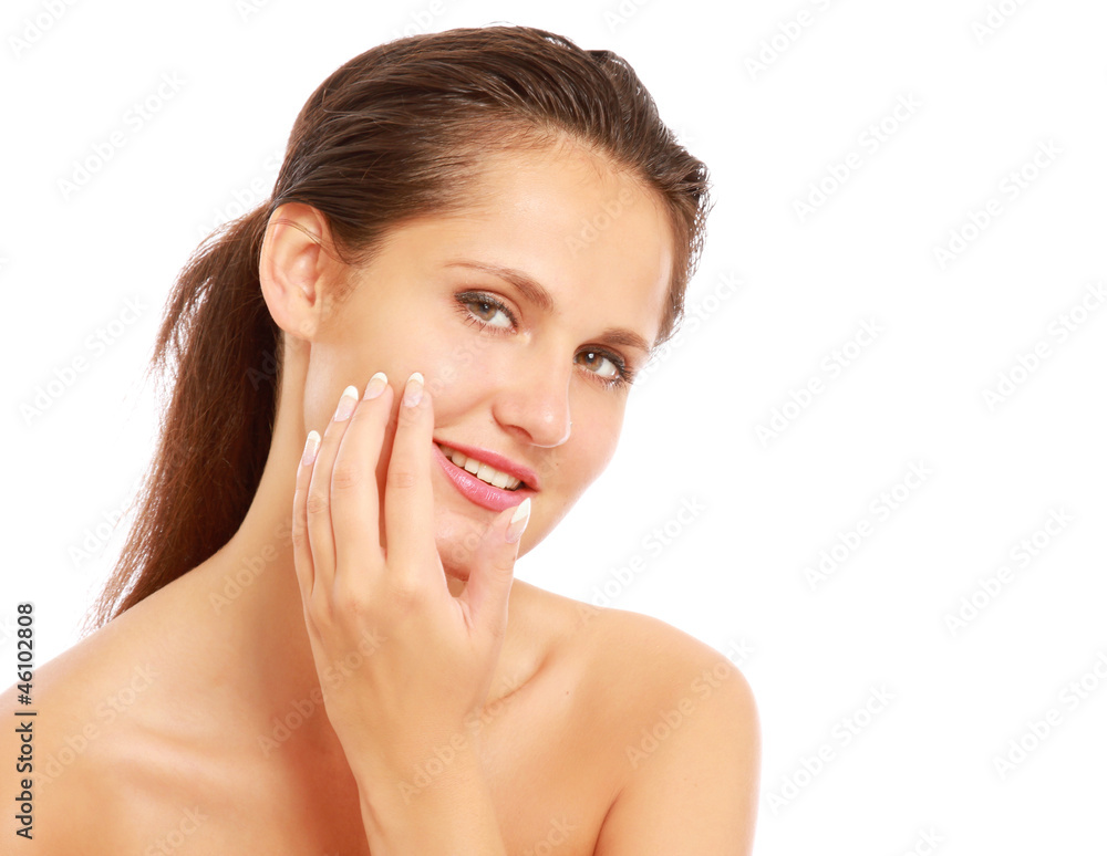 A beautiful woman is applying cream on her face over white A beautiful woman is applying cream on her face over white