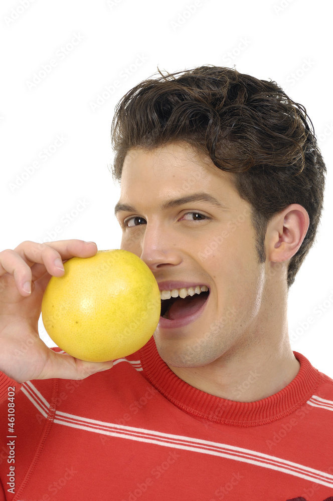 Smiling young man biting an orange Smiling young man biting an orange