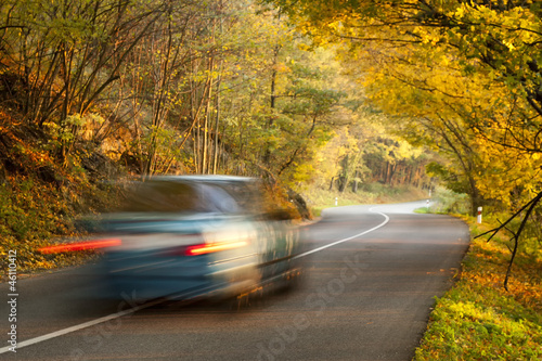 Moving car on the road in autumn nature