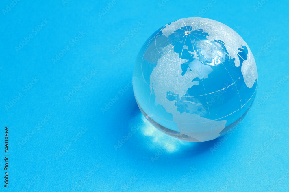 A glass globe, isolated on blue background A glass globe, isolated on blue background