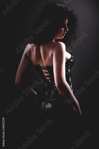 desired brunette woman posing in leather corset