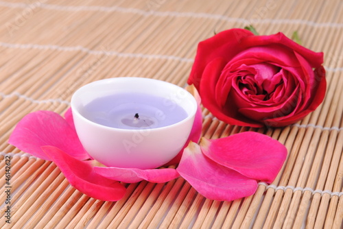 rose and a candle on a bamboo place mat