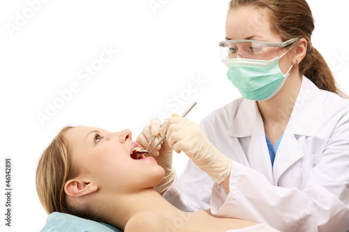 The dentist is examining teeth of a patient
