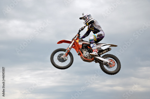Fototapeta Naklejka Na Ścianę i Meble -  motocross rider jumps high against the sky