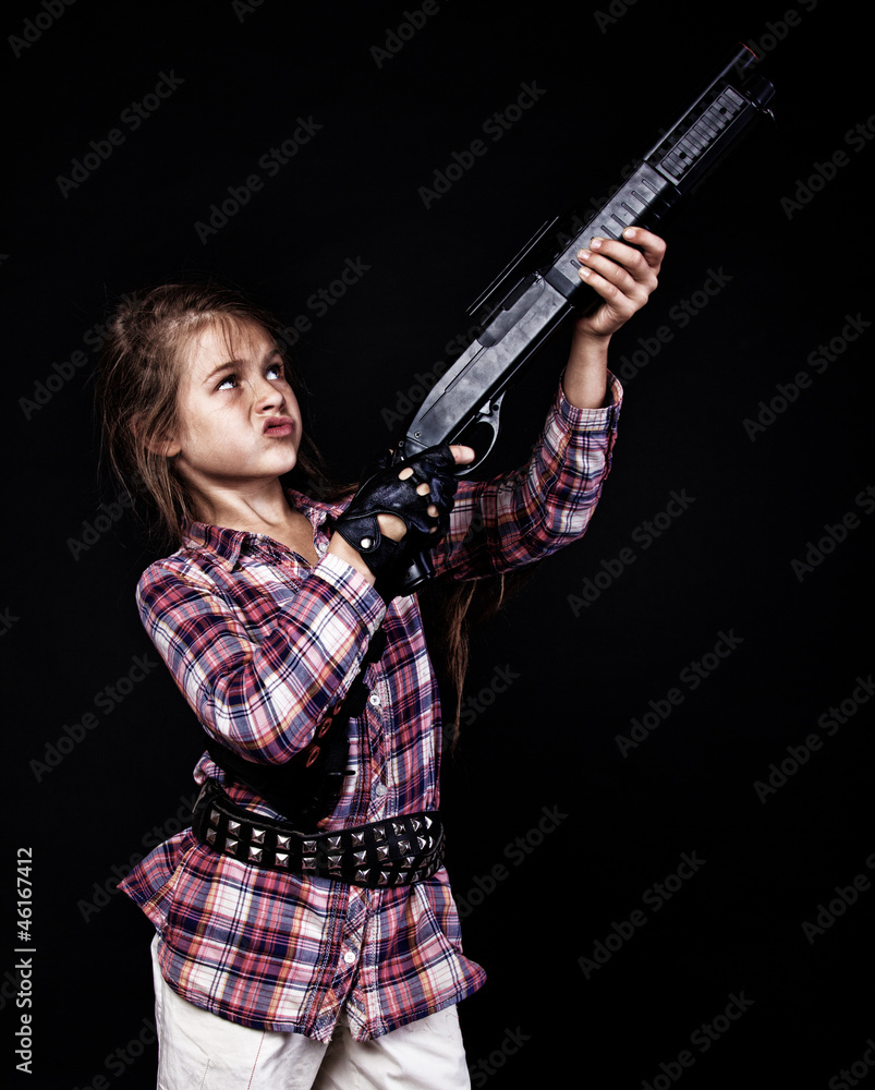 Portrait of beautiful girl posing in studio with gun