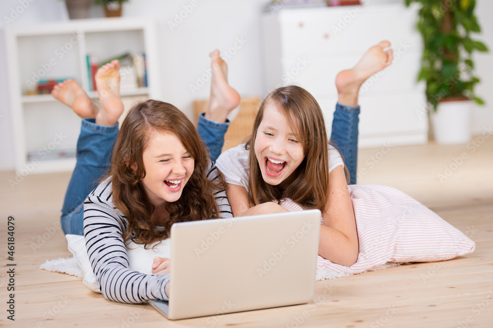 zwei lachende mädchen schauen auf den laptop zwei lachende mädchen schauen auf den laptop