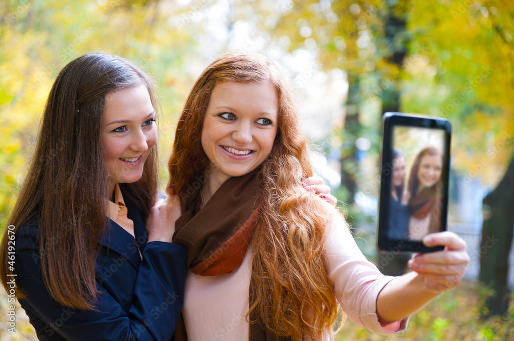 Two girls taking picture with digital tablet Two girls taking picture with digital tablet