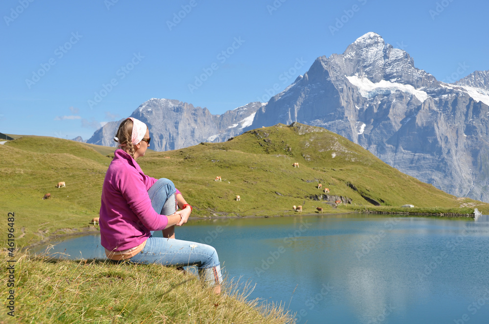 Fototapeta premium Traveler in the Alpine meadow. Jungfrau region, Switzerland