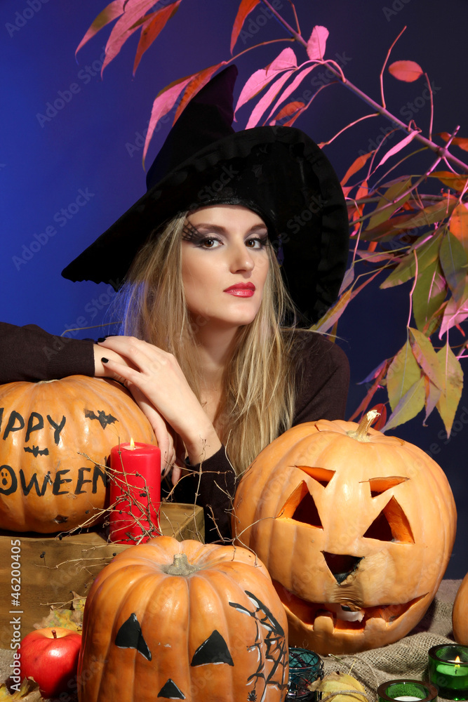 Halloween witch with pumpkins on color background Halloween witch with pumpkins on color background