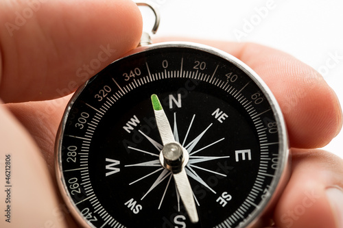 Hand holding silver black compass