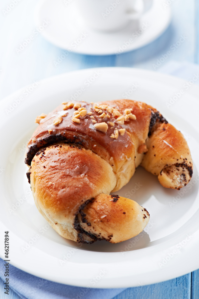 Sweet poppy seed croissant on a plate Sweet poppy seed croissant on a plate
