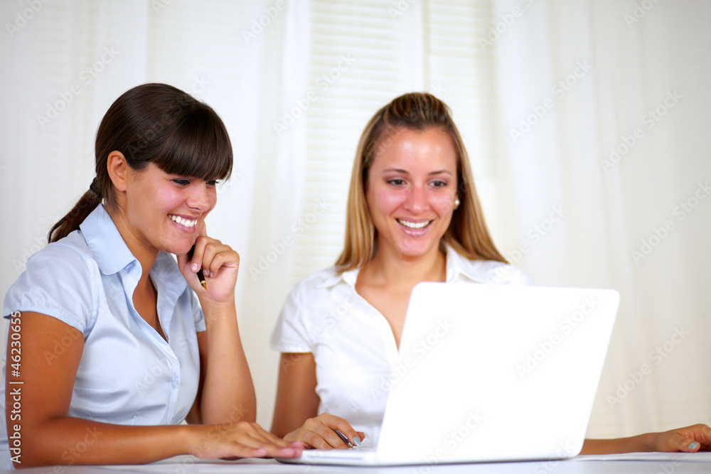 Smiling worker women reading on laptop screen Smiling worker women reading on laptop screen