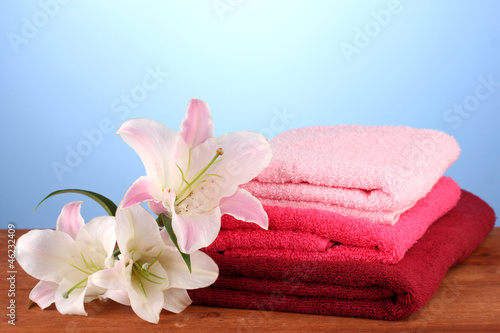 stack of towels with pink lily on blue background.