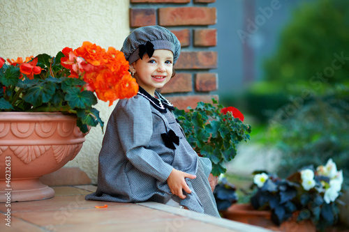 cute little baby girl sitting on house porch steps