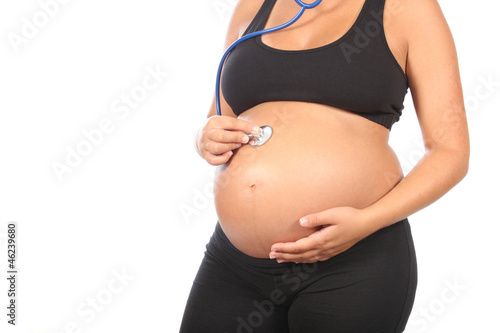 beautiful pregnant woman being examined with a stethoscope