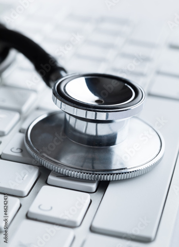 Close up of stethoscope on laptop keyboard. Health concept