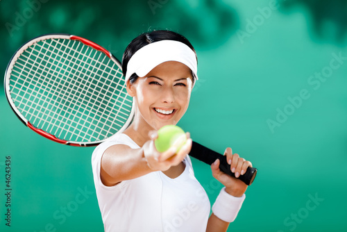 Woman in sportswear serves tennis ball. Competition
