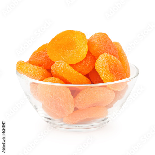 Glass bowl with dried apricots isolated on white background