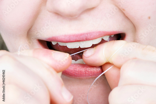 Young woman flossing her teeth
