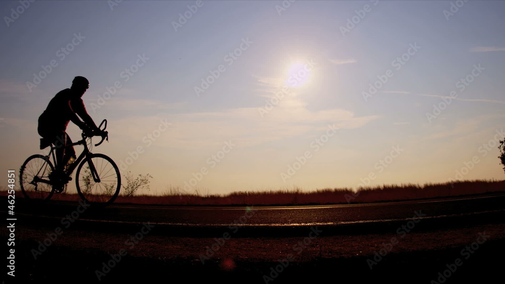 Sunset silhouette active cyclist on track Sunset silhouette active cyclist on track