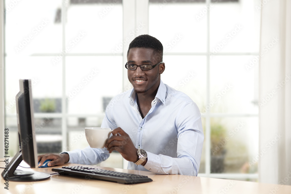 Young man with cup of coffee in front of the PC Young man with cup of coffee in front of the PC